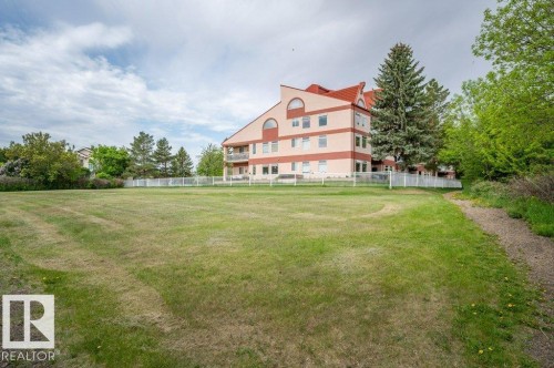 Multi-story building with a distinctive red roof and light-colored siding - 316 2011 137 Avenue, Edmonton, AB - Outdoor