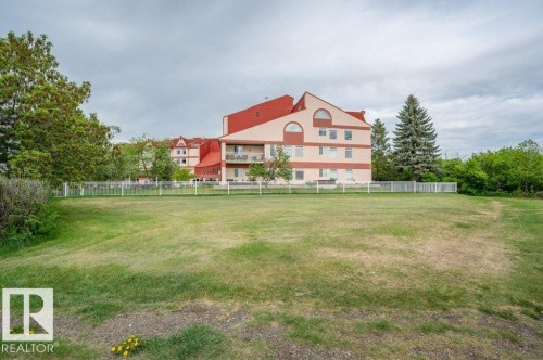 Expansive grassy area with a partial white picket fence - 316 2011 137 Avenue, Edmonton, AB - Outdoor