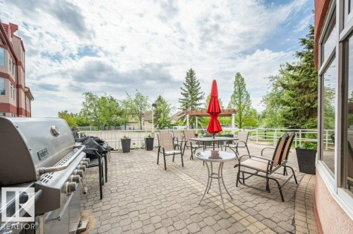Expansive paver patio with a stainless steel outdoor grill, perimeter railing, and mature trees - 316 2011 137 Avenue, Edmonton, AB - Outdoor
