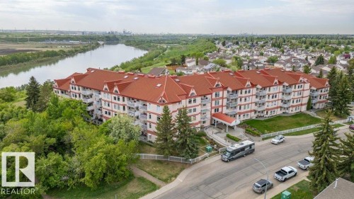 Multi-story residential building featuring a prominent red roofline and numerous private balconies - 316 2011 137 Avenue, Edmonton, AB - Outdoor With View