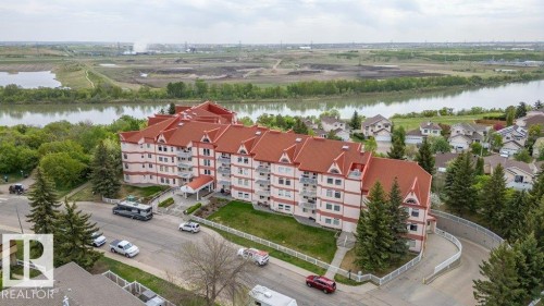 Multi-story residential building featuring a prominent red tile roofline and multiple private balconies - 316 2011 137 Avenue, Edmonton, AB - Outdoor With Body Of Water With View