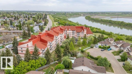 Expansive multi-story building featuring a red roofline and numerous balconies - 316 2011 137 Avenue, Edmonton, AB - Outdoor With Body Of Water With View