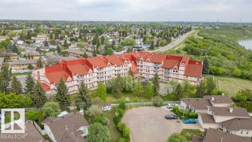 Multi-story residential building with a distinctive red roof and white facade - 316 2011 137 Avenue, Edmonton, AB - Outdoor With View