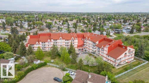 Multi-story building featuring a prominent red roofline and light-colored siding - 316 2011 137 Avenue, Edmonton, AB - Outdoor With View