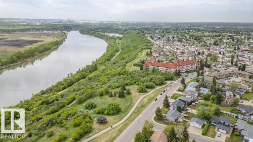 Aerial perspective showcasing a meandering river bordered by abundant green spaces and a residential community - 316 2011 137 Avenue, Edmonton, AB - Outdoor With View