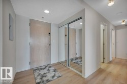 Entryway featuring wood-finish flooring, recessed lighting, and a mirrored closet with sliding doors - 