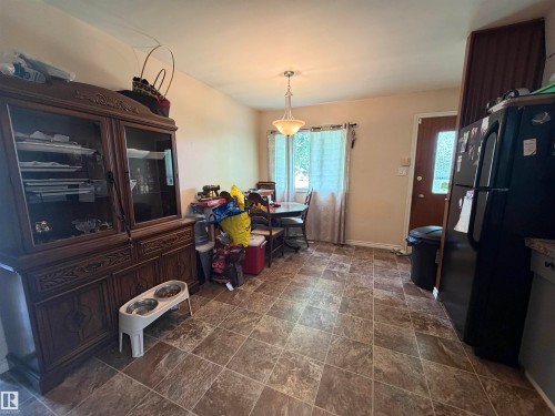 Kitchen area featuring patterned tile flooring, a window with natural light, and a ceiling-mounted light fixture - 5303 119 Avenue, Edmonton, AB 