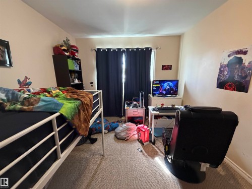 Carpeted room featuring a single window with dark drapes, light-colored walls, and white trim - 5303 119 Avenue, Edmonton, AB 