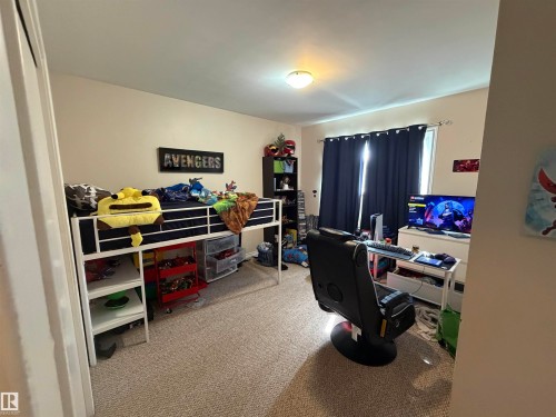 Carpeted room with a single window featuring dark blue curtains - 5303 119 Avenue, Edmonton, AB 