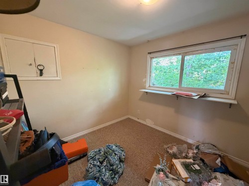 Carpeted room with a double-pane window featuring a window shelf and a built-in access panel - 5303 119 Avenue, Edmonton, AB 