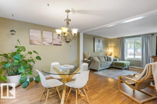 Open-concept living space featuring wood-finish flooring, recessed lighting, and a prominent window - 171 Ridgewood, St. Albert, AB 