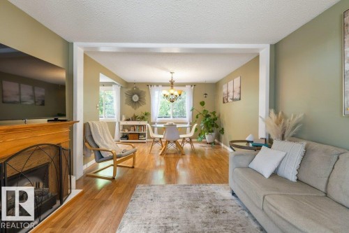 Living area with wood-finish flooring and a decorative fireplace featuring a wooden mantel - 171 Ridgewood, St. Albert, AB 
