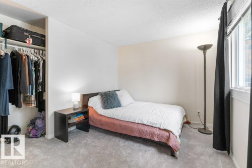 Carpeted room featuring a built-in closet with shelving and hanging rod - 171 Ridgewood, St. Albert, AB 