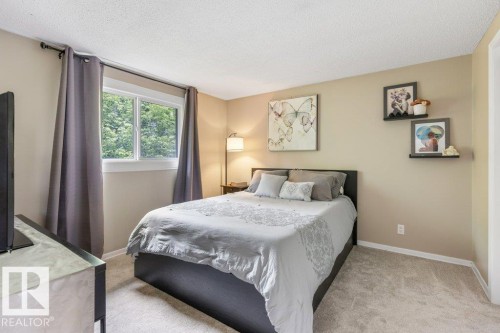 Carpeted room with a double-pane window, neutral-toned walls, and a textured ceiling - 171 Ridgewood, St. Albert, AB 