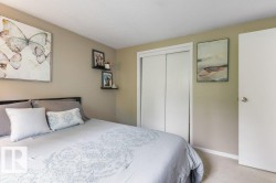 Interior room featuring neutral wall paint, carpet flooring, a white bi-fold closet, and a white interior door with a round knob - 