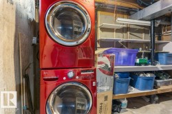 Dedicated laundry area featuring a stacked washer and dryer, adjacent to built-in shelving - 
