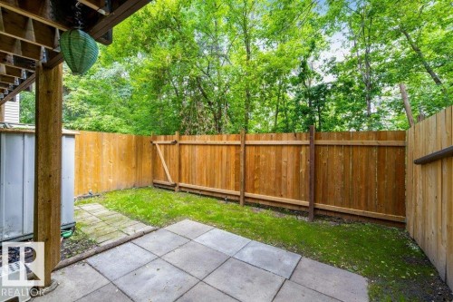 Patio area with square pavers, bordered by a wooden privacy fence - 171 Ridgewood, St. Albert, AB 