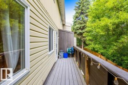 Outdoor deck featuring composite flooring, wood railing with string lighting, and ample natural light - 