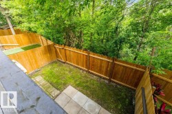 Fenced yard space with a combination of natural grass and artificial turf areas - 