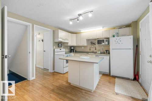 Bright kitchen featuring wood-finish flooring and white cabinetry - 171 Ridgewood, St. Albert, AB 
