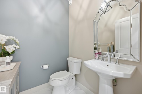 Pedestal sink with chrome fixtures and an ornate framed mirror - 76 Jacobs Close, St. Albert, AB 
