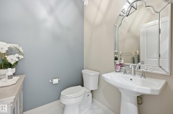 Pedestal sink with chrome fixtures and an ornate framed mirror - 
