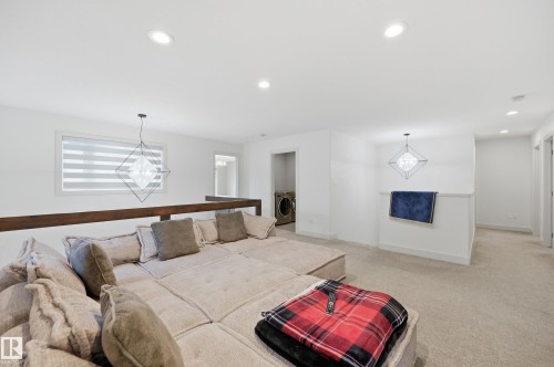 Open loft area featuring recessed lighting, carpeted flooring, a window with horizontal blinds, and a built-in wood railing - 76 Jacobs Close, St. Albert, AB 