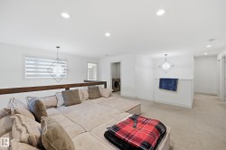 Open loft area featuring recessed lighting, carpeted flooring, a window with horizontal blinds, and a built-in wood railing - 
