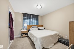 Carpeted room featuring neutral-toned walls, a window with dark curtains, and a flush-mount ceiling light fixture - 