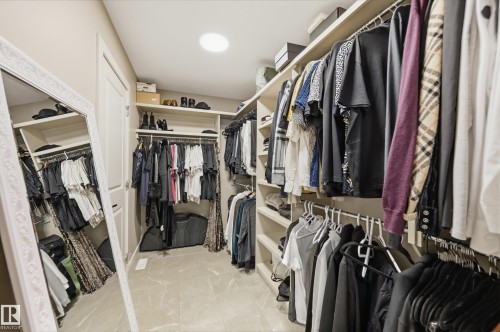 Spacious walk-in closet featuring extensive built-in shelving, multiple hanging rods, and light-toned flooring - 76 Jacobs Close, St. Albert, AB 