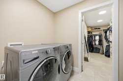 Dedicated laundry area with modern appliances and light-toned wall paint - 