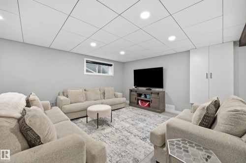 Spacious entertainment room featuring recessed lighting, light gray walls, and wood-finish flooring - 76 Jacobs Close, St. Albert, AB 
