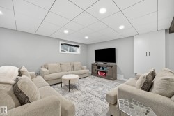 Spacious entertainment room featuring recessed lighting, light gray walls, and wood-finish flooring - 