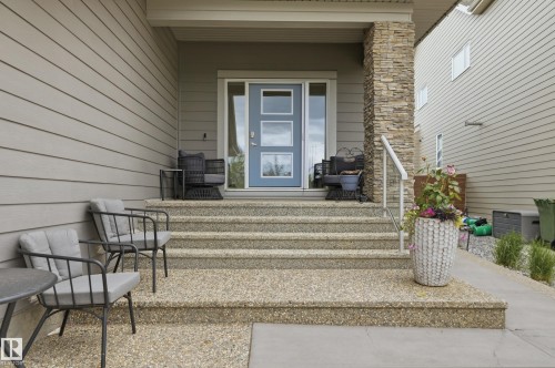 Inviting front entry featuring exposed aggregate steps and a light blue door with frosted glass panels - 76 Jacobs Close, St. Albert, AB 