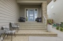 Inviting front entry featuring exposed aggregate steps and a light blue door with frosted glass panels - 76 Jacobs Close, St. Albert, AB 