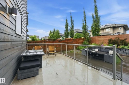 Expansive outdoor patio featuring a glass railing system and a horizontal slat privacy fence - 76 Jacobs Close, St. Albert, AB 