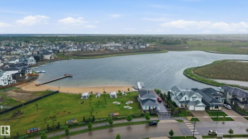 Residential community featuring a lake with a sandy beach and a wooden pier - 76 Jacobs Close, St. Albert, AB 
