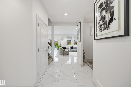 Bright entryway featuring large format white tile flooring with subtle veining and recessed lighting - 76 Jacobs Close, St. Albert, AB 