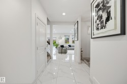 Bright entryway featuring large format white tile flooring with subtle veining and recessed lighting - 