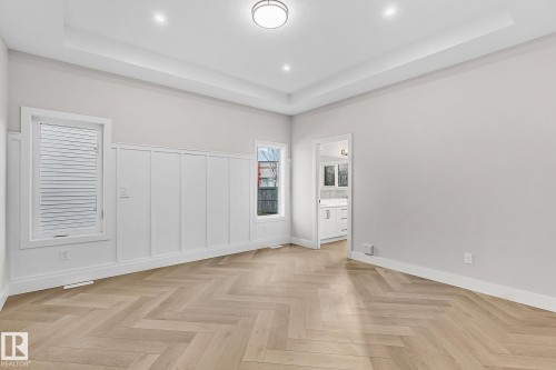 Herringbone wood-finish flooring with a tray ceiling and recessed lighting - 519 Ashgrove Circle, Leduc, AB 