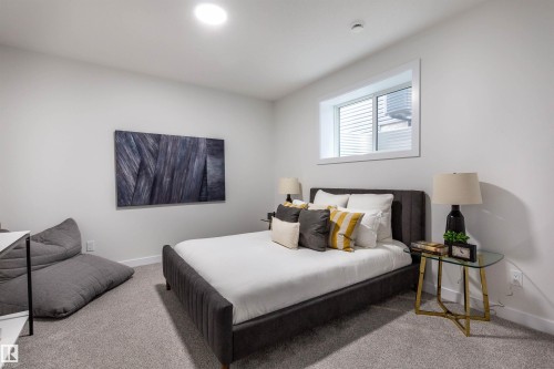 Inviting bedroom featuring plush carpeting, a large window, recessed lighting, and crisp white walls - 519 Ashgrove Circle, Leduc, AB 