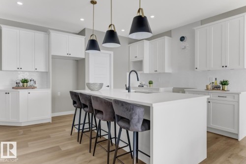 Expansive kitchen island featuring a white countertop and seating for four - 519 Ashgrove Circle, Leduc, AB 