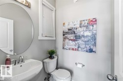 Pedestal sink with chrome fixtures and a circular mirror - 