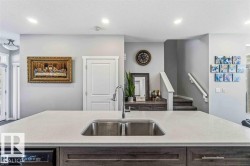 Kitchen island with an undermount double-basin stainless steel sink and a gooseneck faucet - 