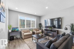Bright living area featuring wood-finish flooring, light grey walls, and recessed lighting - 