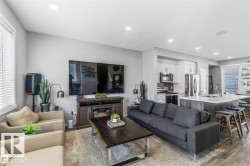 Open concept living area with recessed lighting and wood-finish flooring - 
