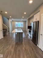 Open concept living space featuring wood-finish flooring and recessed lighting - 