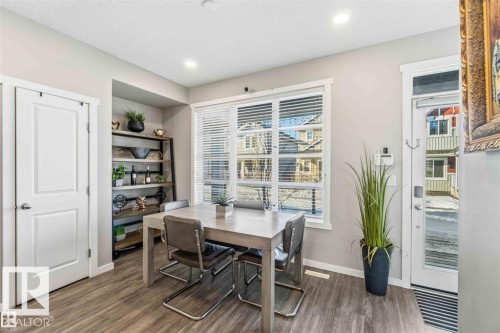 Dining area featuring wood-finish flooring, recessed lighting, and a large window with blinds - 1908 25 Street, Edmonton, AB 