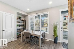 Dining area featuring wood-finish flooring, recessed lighting, and a large window with blinds - 