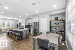 Open-concept living space featuring wood-finish flooring throughout - 